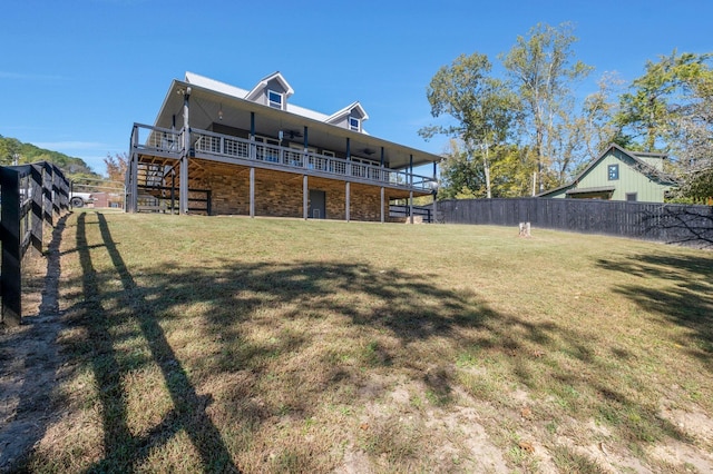 back of property with a lawn and a deck