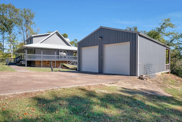 garage featuring a lawn and covered porch