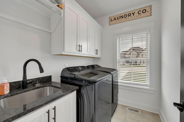 laundry area with washing machine and clothes dryer, a wealth of natural light, cabinets, and sink