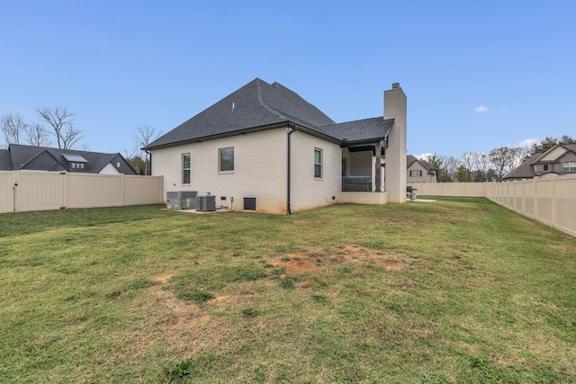 back of property featuring a yard and central air condition unit