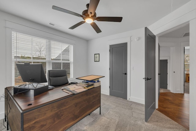 office space with ceiling fan and light carpet