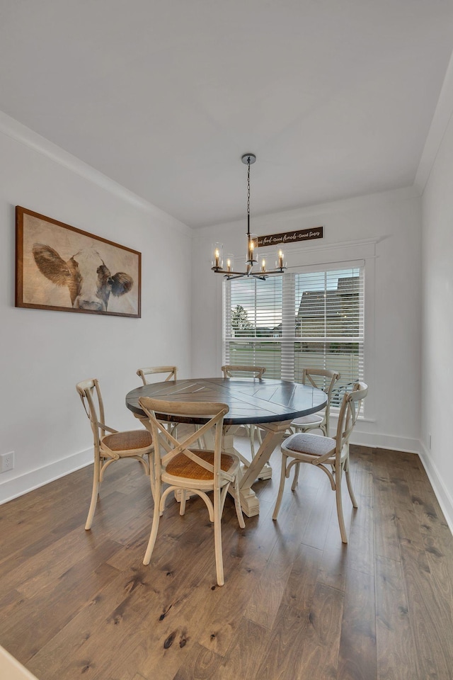 dining space with hardwood / wood-style flooring, ornamental molding, and a chandelier