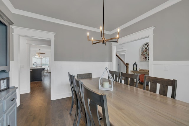 dining space with dark hardwood / wood-style flooring, sink, crown molding, and an inviting chandelier