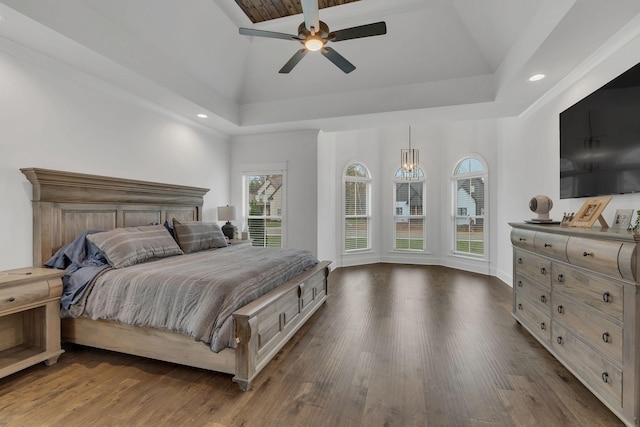 bedroom featuring ceiling fan, a raised ceiling, dark wood-type flooring, and vaulted ceiling