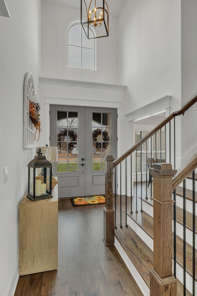 entrance foyer with a chandelier, a high ceiling, and dark wood-type flooring