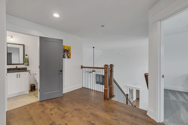 hall with light wood-type flooring and sink