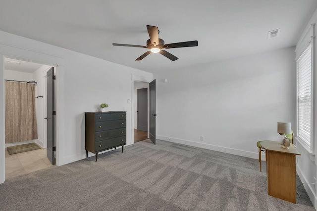 unfurnished bedroom with ensuite bathroom, ceiling fan, and light colored carpet