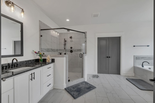 bathroom featuring vanity and independent shower and bath