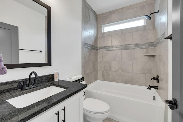 full bathroom featuring vanity, tiled shower / bath combo, and toilet