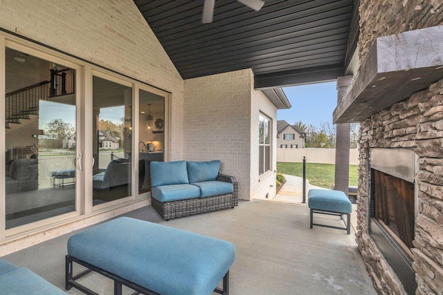 view of patio with an outdoor stone fireplace and ceiling fan