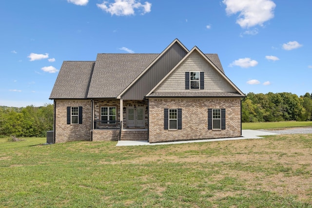 back of property featuring covered porch and a lawn