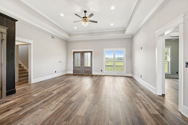 unfurnished living room featuring ceiling fan, a raised ceiling, dark wood-type flooring, and french doors