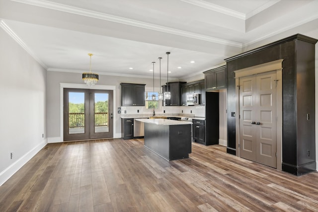 kitchen featuring pendant lighting, a kitchen island, crown molding, and stainless steel appliances