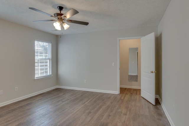 unfurnished room featuring a textured ceiling, light hardwood / wood-style flooring, and ceiling fan