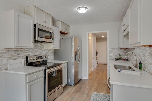 kitchen featuring white cabinetry, sink, and appliances with stainless steel finishes