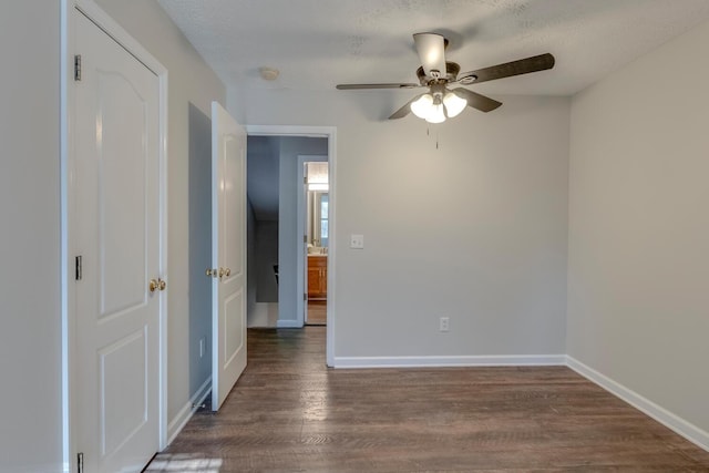 unfurnished room with a textured ceiling, ceiling fan, and dark hardwood / wood-style floors