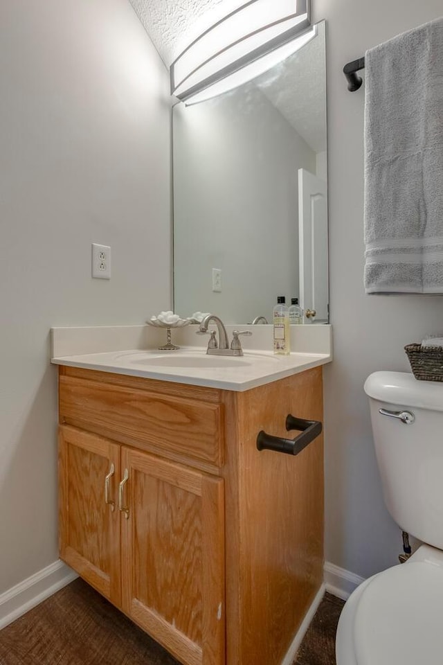 bathroom with vanity, toilet, and a textured ceiling