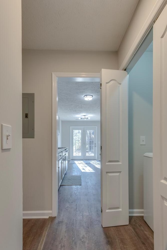 hallway featuring electric panel, french doors, dark wood-type flooring, and a textured ceiling