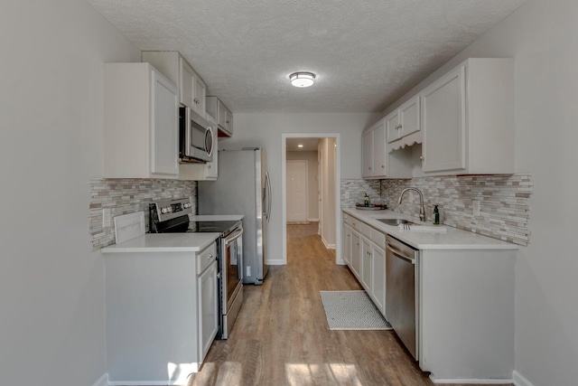 kitchen with white cabinets, sink, appliances with stainless steel finishes, and a textured ceiling