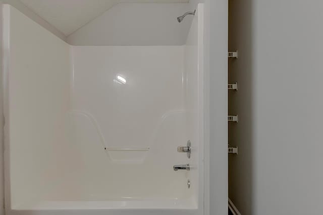 bathroom featuring shower / bathtub combination and vaulted ceiling