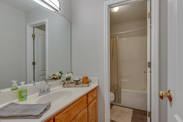 full bathroom featuring vanity, shower / tub combo, a textured ceiling, and toilet