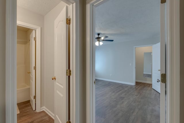 hall featuring a textured ceiling and hardwood / wood-style flooring