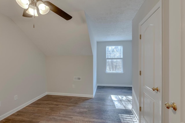 additional living space featuring ceiling fan, wood-type flooring, a textured ceiling, and vaulted ceiling