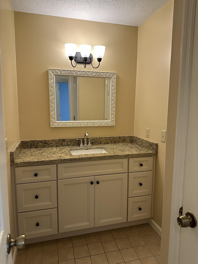 bathroom featuring tile patterned floors, vanity, and a textured ceiling