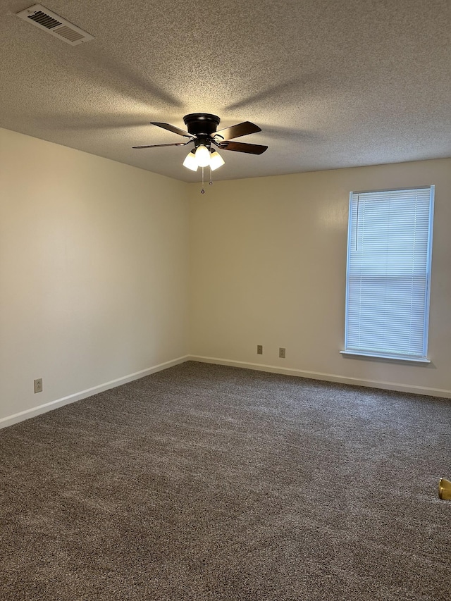 carpeted spare room featuring ceiling fan and a textured ceiling