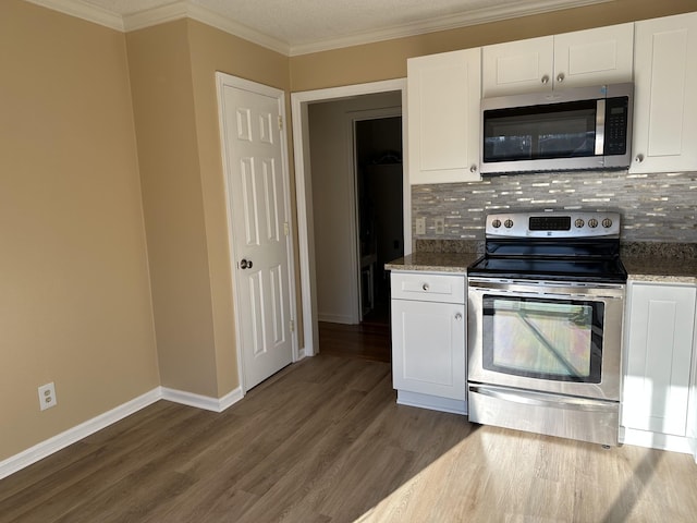 kitchen with white cabinetry, dark hardwood / wood-style floors, dark stone counters, decorative backsplash, and appliances with stainless steel finishes