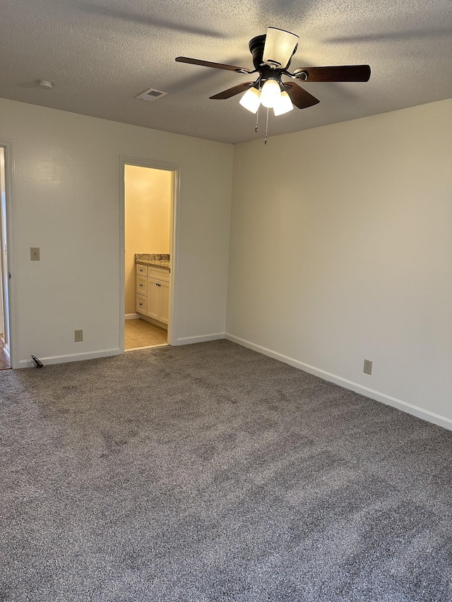 unfurnished bedroom featuring connected bathroom, ceiling fan, light carpet, and a textured ceiling