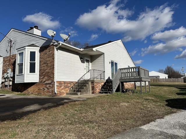 view of home's exterior with a deck and a yard