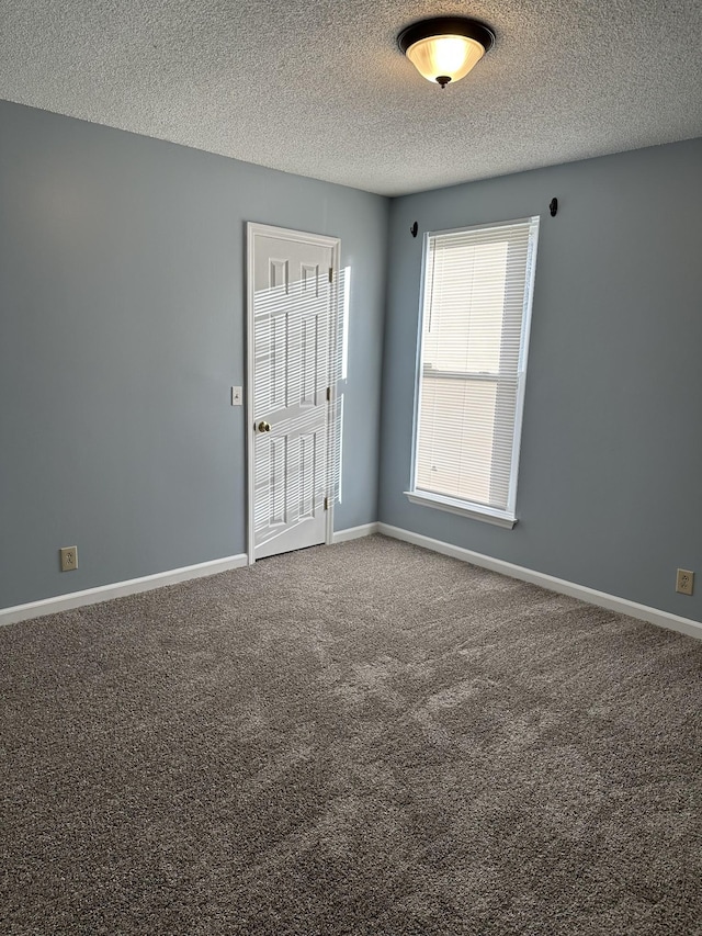 carpeted spare room with a textured ceiling