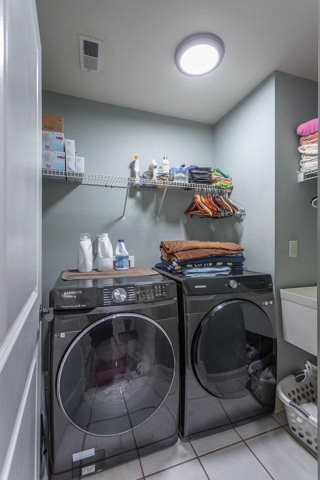 laundry room with tile patterned floors, independent washer and dryer, and sink