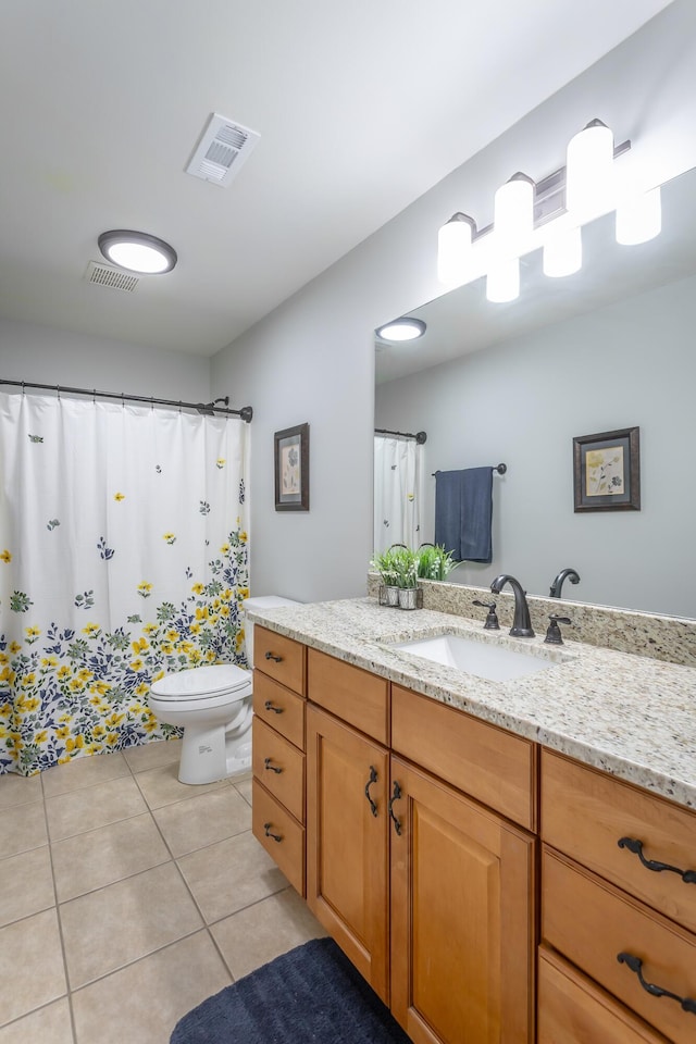 bathroom with tile patterned flooring, vanity, and toilet