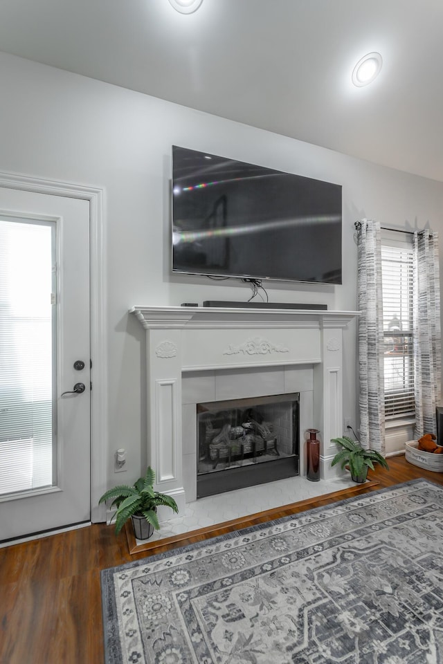 interior details featuring hardwood / wood-style floors and a tile fireplace