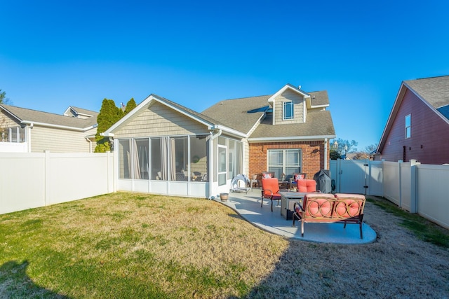 back of house featuring a yard, a patio, and a sunroom