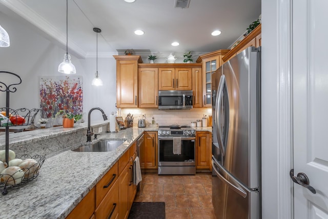 kitchen featuring tasteful backsplash, light stone counters, stainless steel appliances, sink, and decorative light fixtures