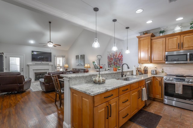 kitchen featuring sink, hanging light fixtures, light stone countertops, kitchen peninsula, and stainless steel appliances