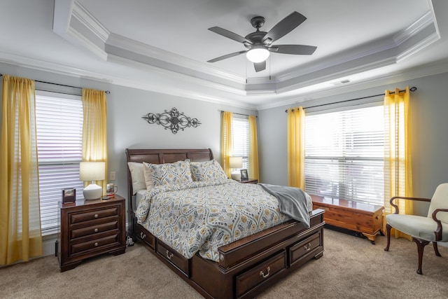 carpeted bedroom featuring a tray ceiling, ceiling fan, and crown molding