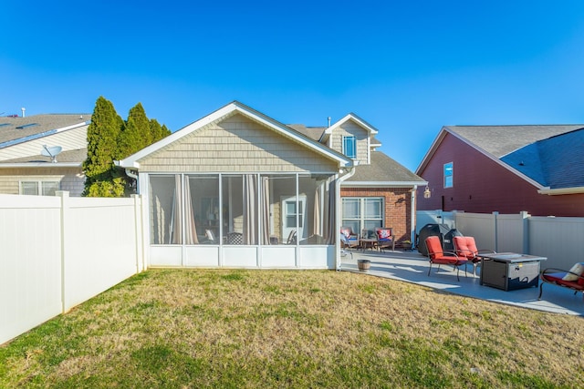 back of property featuring a sunroom, a yard, and a patio