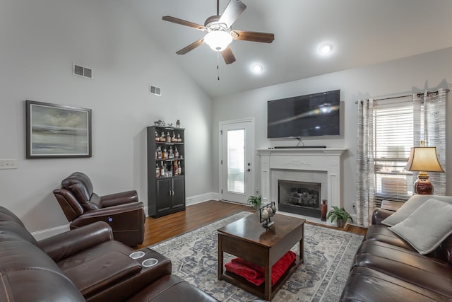 living room featuring hardwood / wood-style flooring, high vaulted ceiling, and ceiling fan