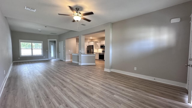 unfurnished living room featuring light hardwood / wood-style flooring and ceiling fan