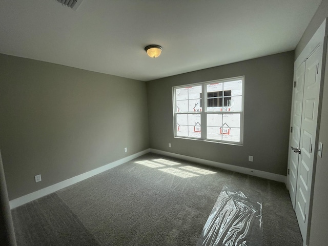 unfurnished bedroom with dark carpet