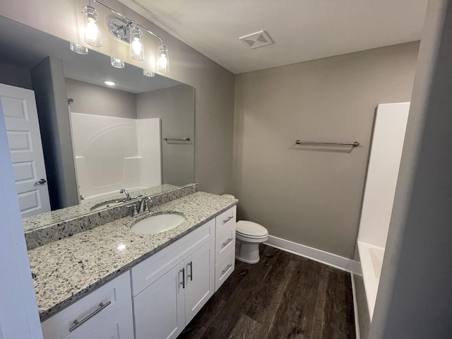 full bathroom featuring hardwood / wood-style floors, vanity, tub / shower combination, and toilet