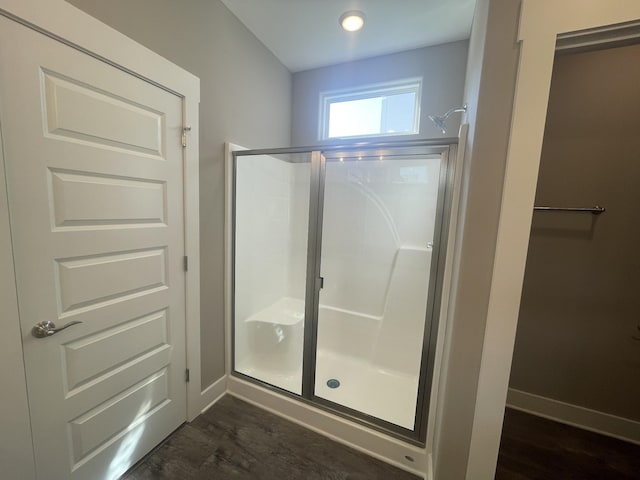 bathroom featuring wood-type flooring and a shower with shower door