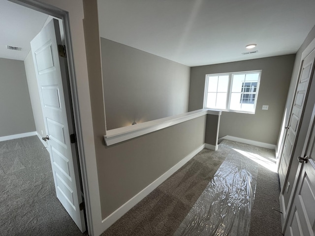 corridor with dark colored carpet