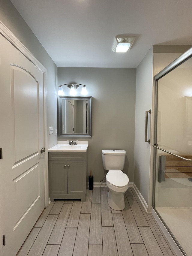 bathroom featuring vanity, toilet, and an enclosed shower