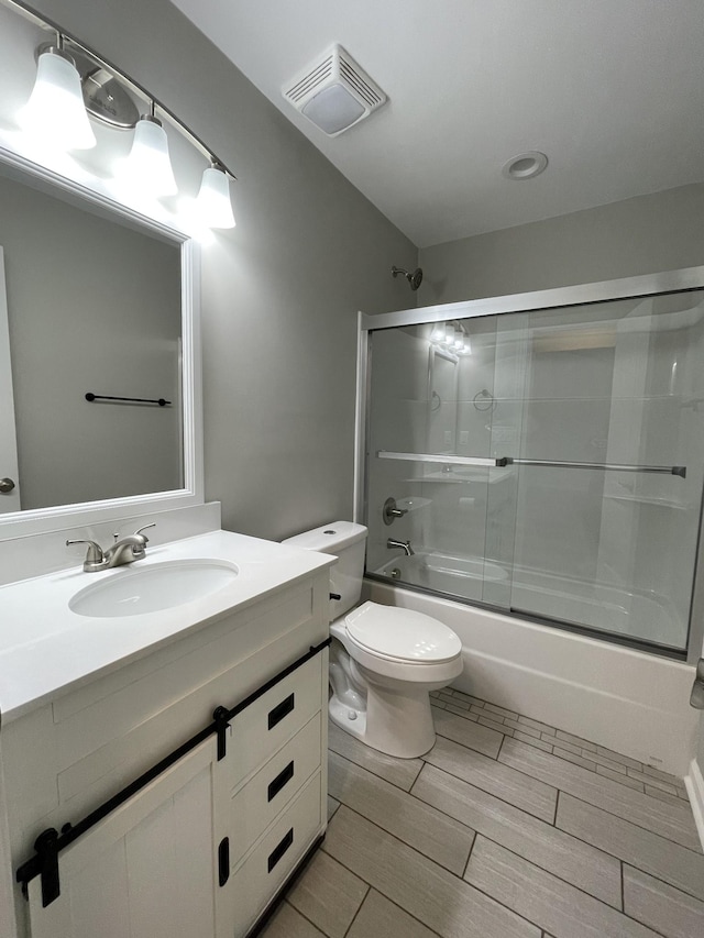 full bathroom with vanity, toilet, and bath / shower combo with glass door