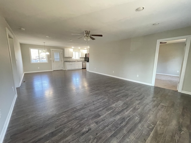 unfurnished living room with ceiling fan and dark wood-type flooring